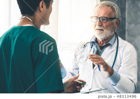 Senior male doctor working with another doctor. 48313496