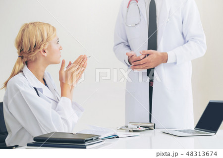 Female doctor at hospital talking to her partner. 48313674