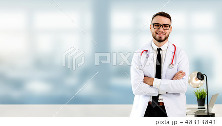 Handsome doctor standing in hospital office. 48313841