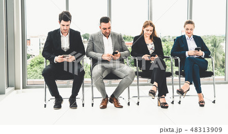 Businesswomen and businessmen using mobile phone. Businesswomen and businessmen using mobile phone. 48313909