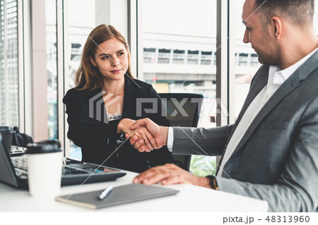 Businessman handshake businesswoman in office. Businessman handshake businesswoman in office. 48313960