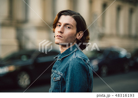Handsome young adult man on city street Handsome young adult man on city street 48316193