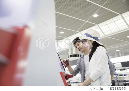 空港で自動チェックイン機を使うカップル、夫婦 48318346
