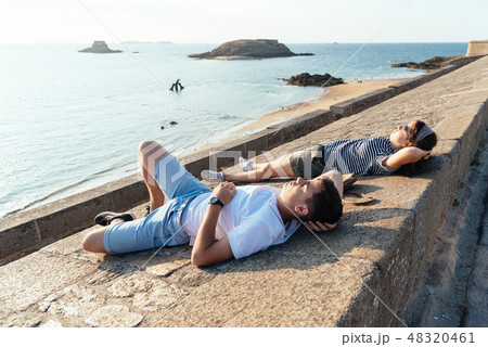 Portrait of young couple  relaxing lying on the walls   48320461