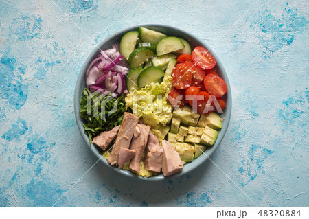 Avocado Tuna Salad in a plate on blue table.  48320884