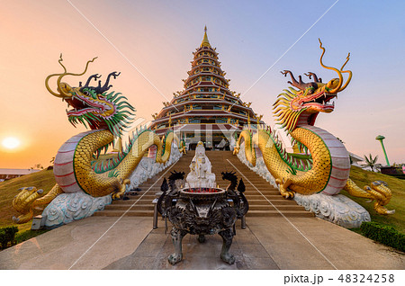 The dragons statue is between the pagoda at sunset The dragons statue is between the pagoda at sunset 48324258