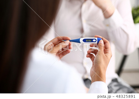 hands of a female doctor holding a thermometer 48325891