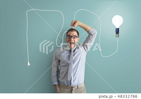 Young man smiles and holds a bright light bulb 48332766