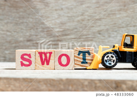 Toy bulldozer hold letter block T to word swot 48333060