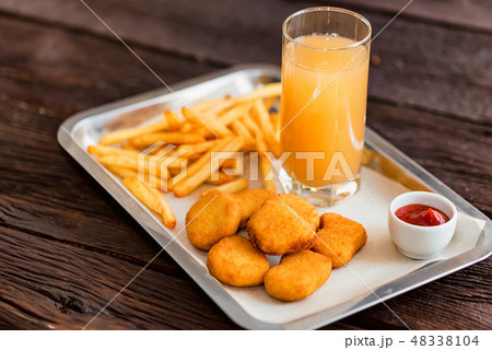 Close up chicken nuggets and fries with sauce and juice on plate 48338104