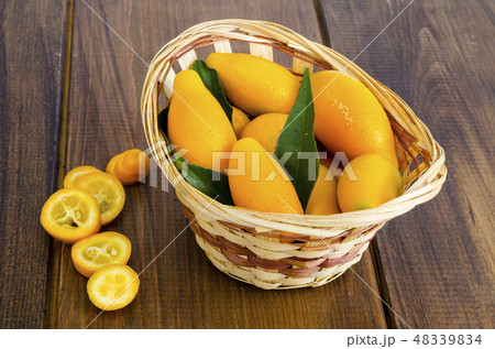 Ripe sweet orange kumquats fortunella in wooden Ripe sweet orange kumquats fortunella in wooden 48339834