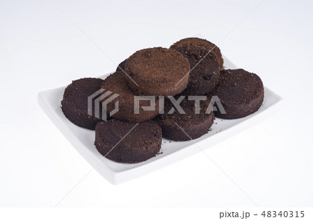 Pressed waste coffee beans on white background Pressed waste coffee beans on white background 48340315