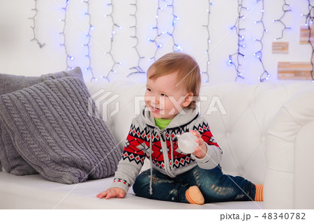 Cute little boy is sitting on the couch at home Cute little boy is sitting on the couch at home 48340782