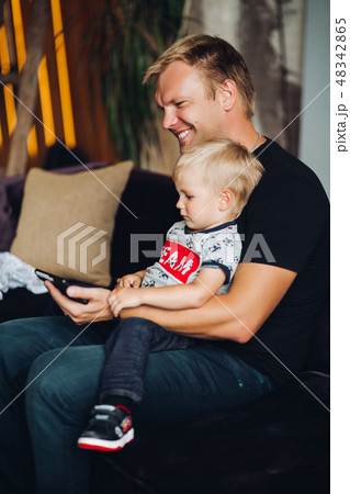 Happy father and son watching cartoons together. 48342865