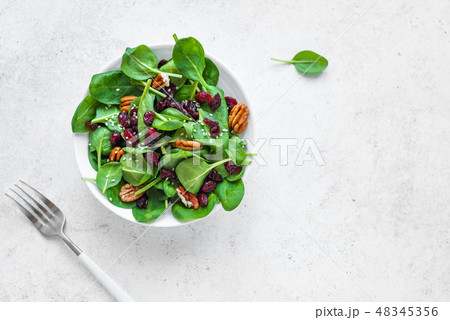Spinach, apple salad with pecan nuts and cranberries Spinach, apple salad with pecan nuts and cranberries 48345356