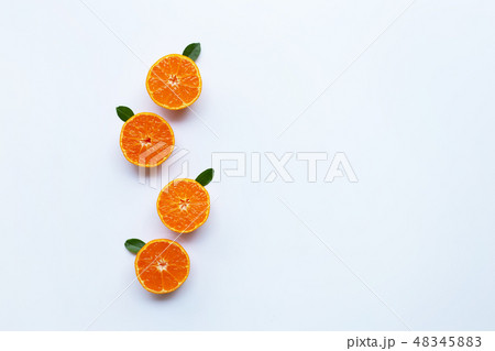 Orange fruits and green leaves on a white 48345883