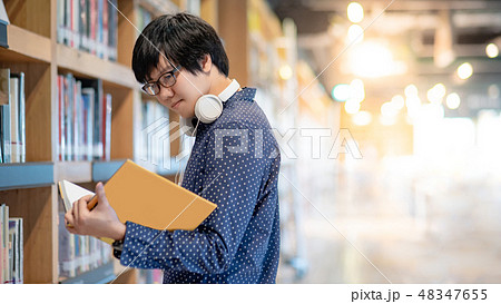 Asian man student reading book in library Asian man student reading book in library 48347655