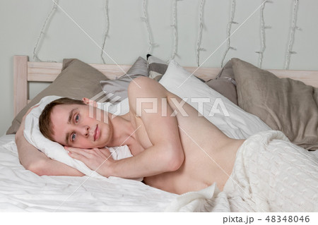 Handsome young adult man sleeping in bed Handsome young adult man sleeping in bed 48348046