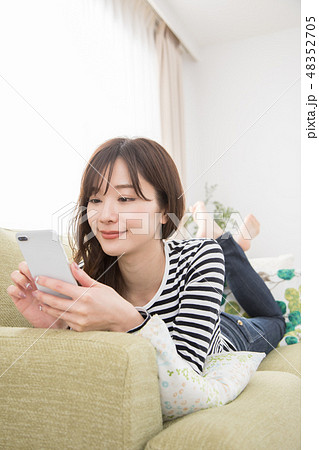 ソファーでスマホを使う女性 48352705