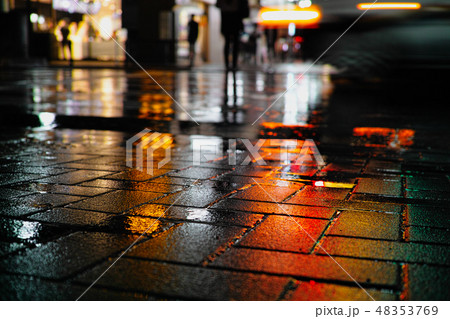 Orange reflected on the road at a busy crossing 48353769