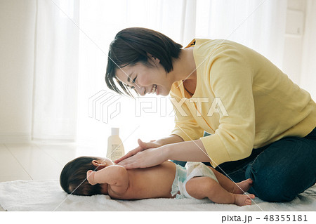 赤ちゃんにベビーマッサージをする若い母親 48355181