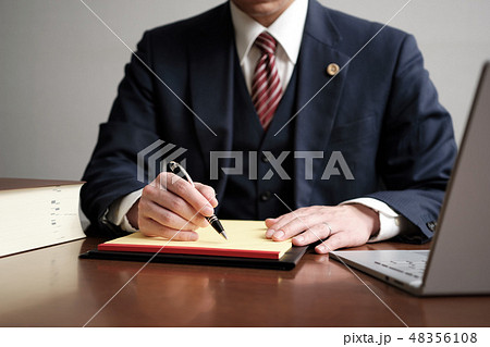 リーガルパッドにメモをする男性弁護士 48356108