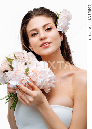 Portrait girl smiling and posing with artificial flowers on white background. Portrait girl smiling and posing with artificial flowers on white background. 48356697