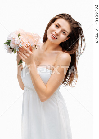 Portrait girl smiling and posing with artificial flowers on white background. Portrait girl smiling and posing with artificial flowers on white background. 48356792