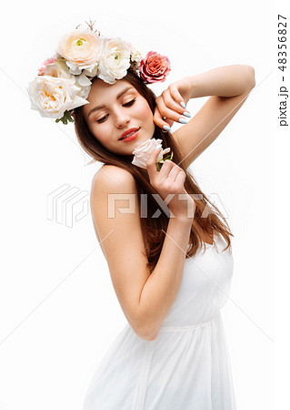 Beautiful young girl smiling and posing with flowers on white background. 48356827
