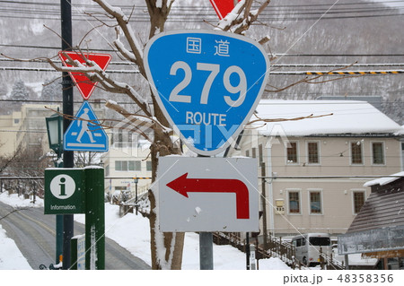 雪が降る日の道路標識(案内標識)「国道番号」(国道279号)。写真奥に見える坂は「八幡坂」。 48358356