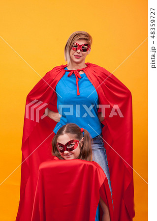 Mother and daughter playing together dressed like superheros 48359727