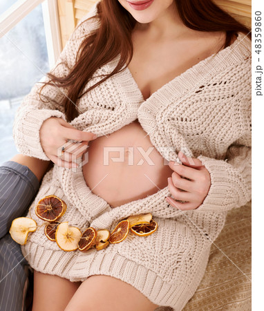 pregnant woman sitting near the window 48359860