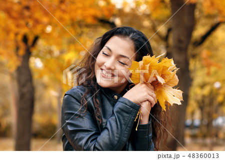 Pretty woman is in autumn park on fallen leaves Pretty woman is in autumn park on fallen leaves 48360013