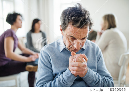 A portrait of senior depressed man during group therapy. 48360346