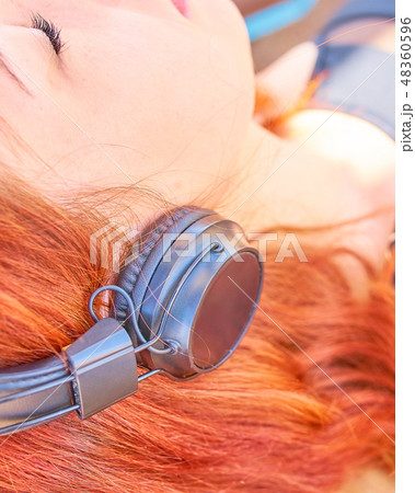 Beautiful woman listening to music on the beach. Beautiful woman listening to music on the beach. 48360596
