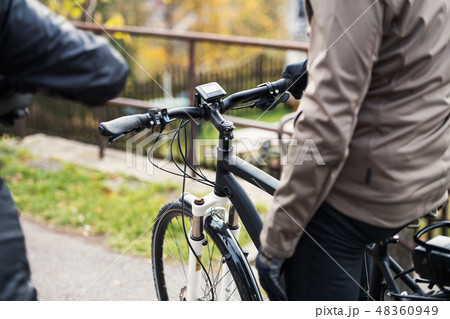 A midsection of active senior couple with electrobikes cycling outdoors. 48360949