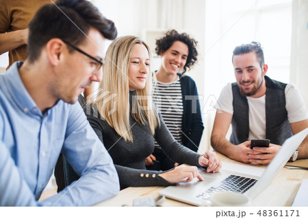 Group of young businesspeople with laptop working together in a modern office. 48361171