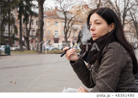 Girl smoking electronic cigarette, Iqos system Girl smoking electronic cigarette, Iqos system 48361480