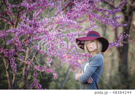 Young woman smiling on the red garden background, copy space 48364244
