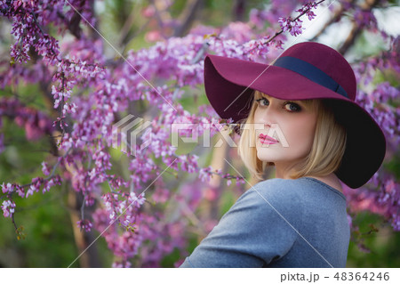 Young woman smiling on the red garden background, copy space Young woman smiling on the red garden background, copy space 48364246