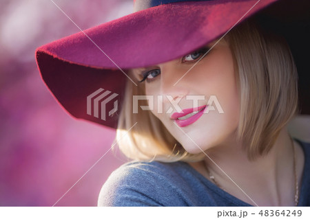 Young woman smiling on the red garden background, copy space Young woman smiling on the red garden background, copy space 48364249