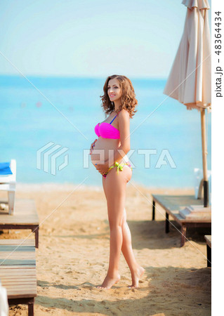 woman in bikini on lounge chair woman in bikini on lounge chair 48364434
