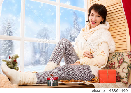 Woman sitting on window sill - sunny day in winter 48364490