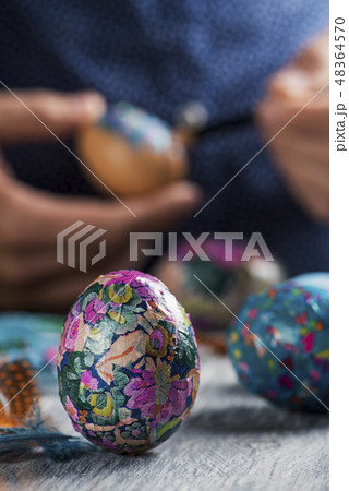 young man decorating homemade easter eggs. 48364570