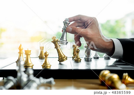 businessman playing chess figure take a checkmate another king businessman playing chess figure take a checkmate another king 48365599