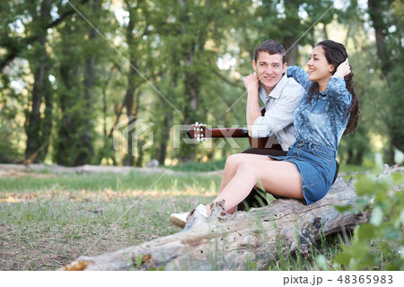 couple walking in the forest and playing guitar couple walking in the forest and playing guitar 48365983