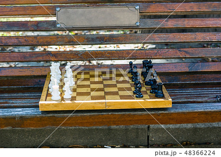 Old chess on wooden bench in city park 48366224