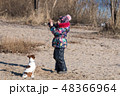little girl in hat and jacket in the winter plays  48366964