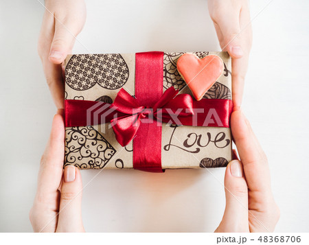 Hands of a parent and a child, box with a gift Hands of a parent and a child, box with a gift 48368706