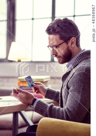 Serious thoughtful man reading the meaning of the card Serious thoughtful man reading the meaning of the card 48368967